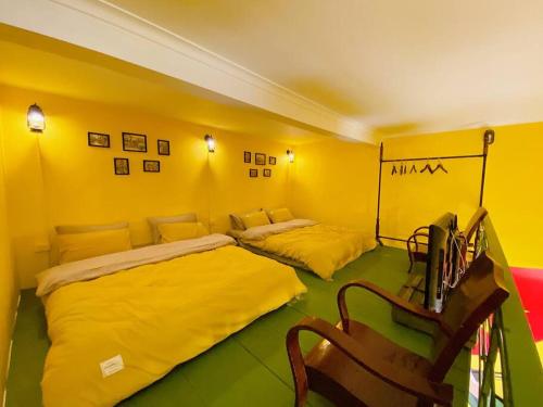 um quarto amarelo com 2 camas e uma secretária em Budget 80s Style Apt @4 guests @WalkingStreet em Hanói