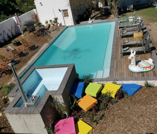 a large swimming pool with colorful chairs next to it at Greyton Toad Hall Guesthouse - no load shedding in Greyton