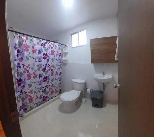 a bathroom with a toilet and a shower curtain at APARTA HOTEL TAYRONA in Soledad