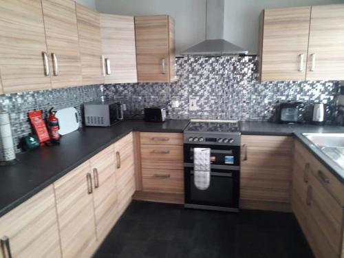 a kitchen with wooden cabinets and a stove top oven at Sea La Vie in Warrenpoint