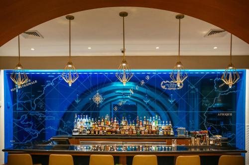een bar met een blauwe muur en kroonluchters bij *New Listing * 1 Bedroom in Luxury Hotel in Fort Lauderdale