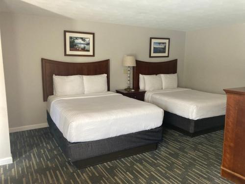 a hotel room with two beds with white sheets at Park Lane Motel in Lake George