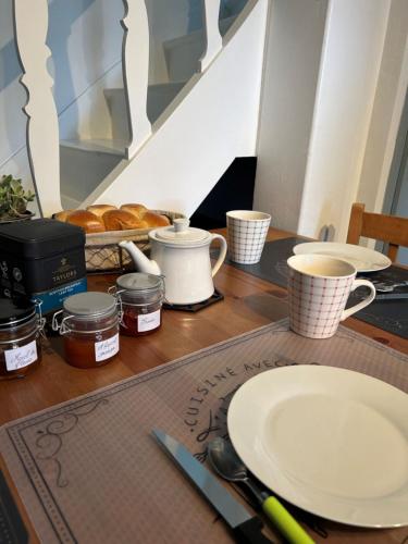 a table with a plate and cups of coffee and croissants at L'escapade, Gîte calme au cœur de Clisson et proche de la Sèvre in Clisson