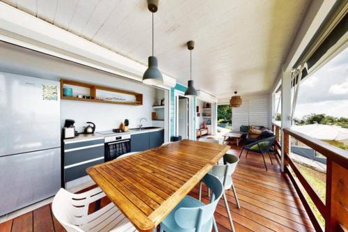 a kitchen and dining room with a wooden table and chairs at Villa Ti Alizés in Sainte-Luce