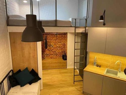 a room with a loft bed and a kitchen with a sink at Łódź You Like in Łódź