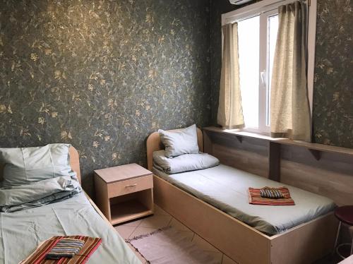 Habitación pequeña con 2 camas y ventana en Lisova - Лісова готельня і сауна, en Kiev