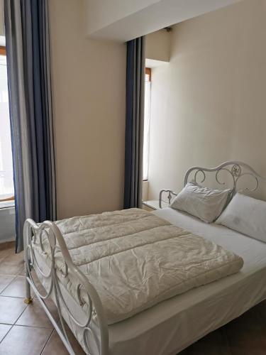 - un lit blanc dans une chambre avec fenêtre dans l'établissement bella appartement cathédrale, à Nevers