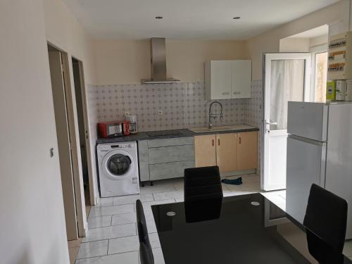 une cuisine avec un réfrigérateur et une machine à laver dans l'établissement bella appartement cathédrale, à Nevers