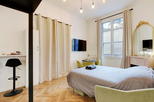 1 dormitorio con cama y ventana grande en Charming apartment in heart of Le Marais - GetHosted en París
