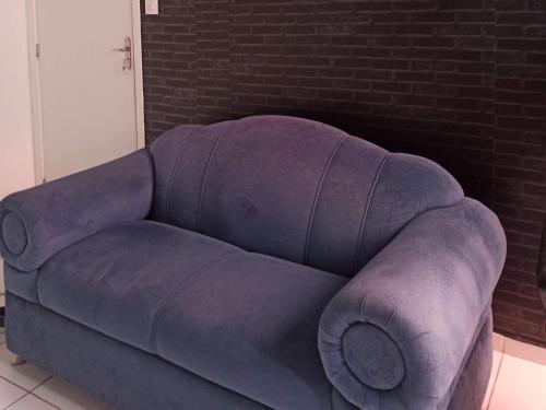 a purple couch in a room with a brick wall at AP Central Park in Feira de Santana