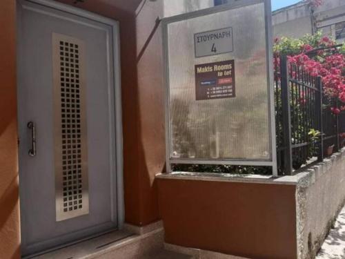 a building with a door and a window with flowers at Makis rooms A in Mesolongion