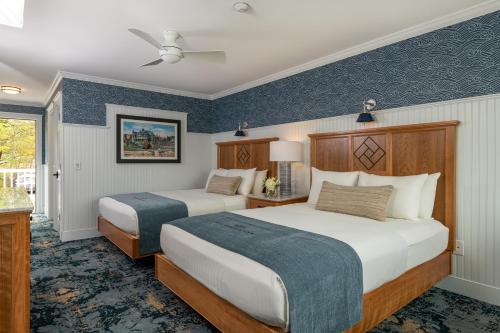 two beds in a hotel room with blue walls at Bar Harbor Inn and Spa in Bar Harbor
