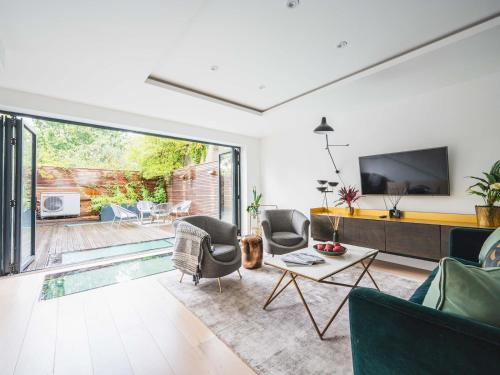 a living room with a tv and a pool at Pass the Keys London Modern EcoTownhouse Dulwich in London