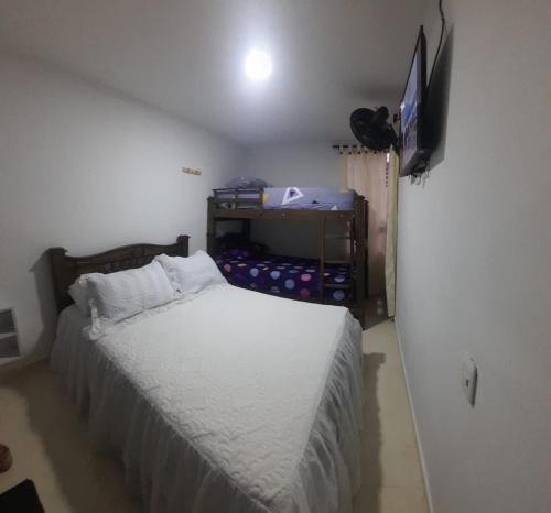 a bedroom with a bed and a flat screen tv at APARTA HOTEL TAYRONA in Soledad