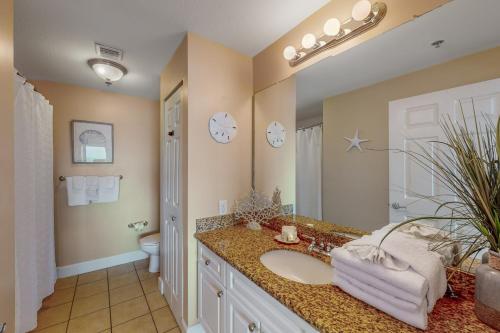 a bathroom with a sink and a toilet and a mirror at Seawind #1109 in Gulf Shores