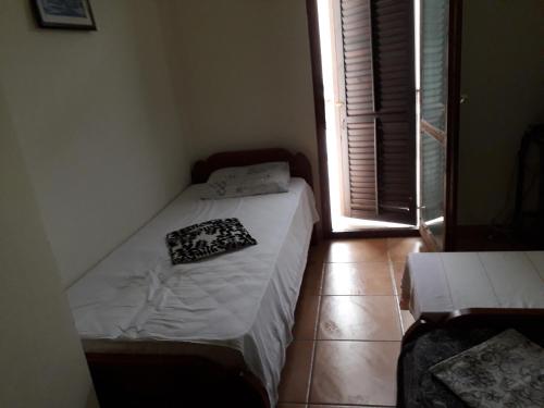 een klein bed in een kamer met een raam bij Apartman Lovcen in Budva