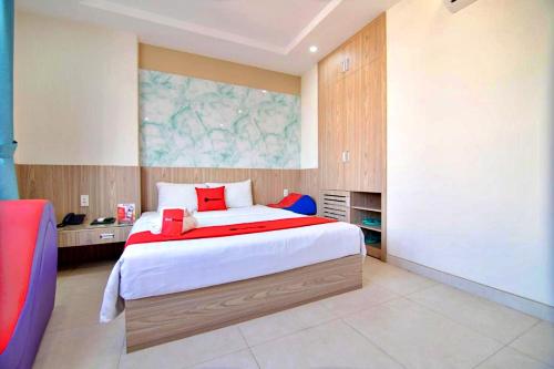 胡志明市的住宿－HANZ Love Hotel Tran Binh Trong，一间卧室配有一张带红色枕头的大床