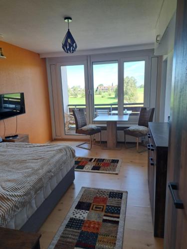 1 dormitorio con 1 cama, mesa y sillas en Ferienwohnung, Monteurwohnung, en Scheidegg