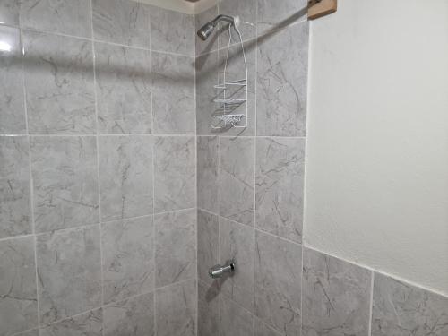 y baño con ducha y puerta de cristal. en Volcano Hostel en León