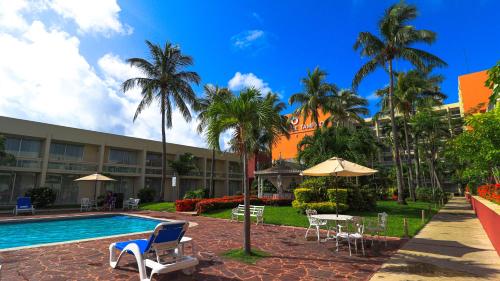 een resort met een zwembad, stoelen en palmbomen bij Posada de Tampico in Tampico