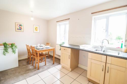 una cucina con tavolo e una sala da pranzo di 4 Bedroom House with FREE WIFI AND DRIVEWAY! a Hillingdon