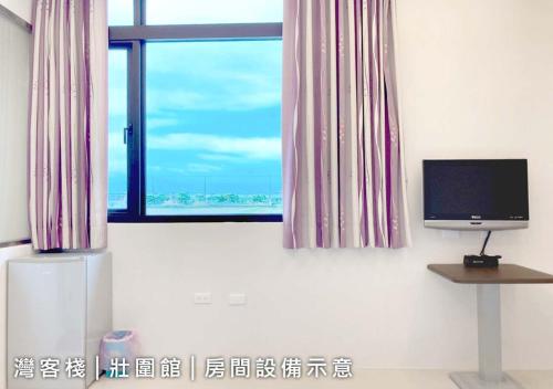 sala de estar con TV y ventana en 灣客棧壯圍56館 en Yilan City