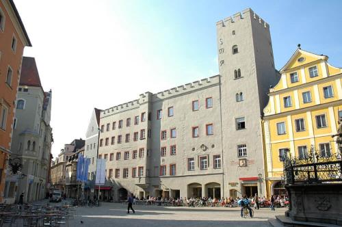 a group of buildings in a city with people at Hotel Das Regensburg in Regensburg