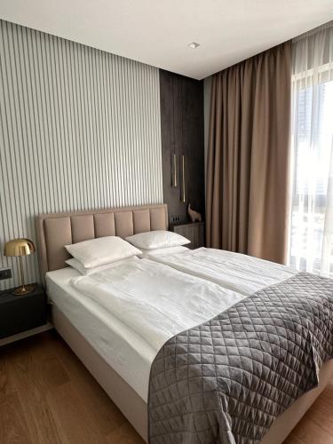een slaapkamer met een groot bed en een raam bij DOM Boutique Apartments - Verde in Belgrado