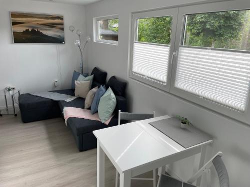 a living room with a couch and a table and windows at CASALINO DI ANNA 2 in Wensickendorf