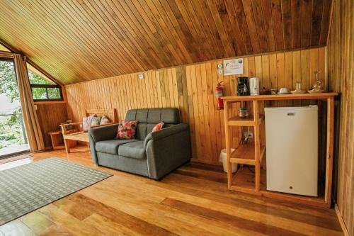 a living room with a couch and a chair at Tityra Lodge in Monteverde Costa Rica