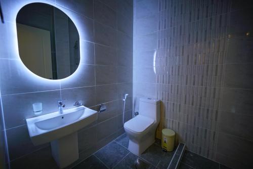 uma casa de banho com um lavatório, um WC e um espelho. em simple street apartment em Wadi Musa