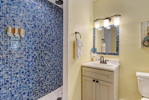 a blue tiled bathroom with a sink and a mirror at Siesta Key Palms Resort in Sarasota