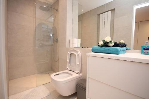 La salle de bains blanche est pourvue d'une douche et de toilettes. dans l'établissement Lovely flat in Baker street, à Londres
