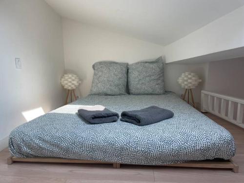 Un dormitorio con una cama con dos almohadas encima. en Appartement cosy au cœur de l’Écusson, en Montpellier