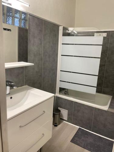 une salle de bain avec un lavabo blanc et un miroir dans l'établissement Appartement cosy au cœur de l’Écusson, à Montpellier