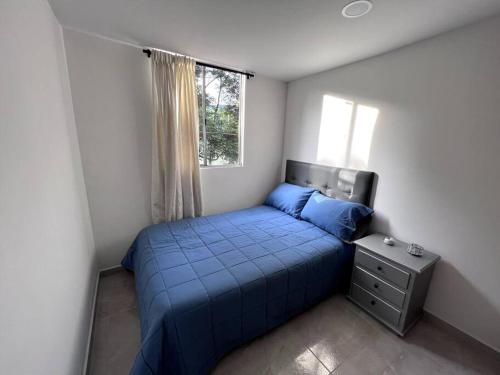 Un pequeño dormitorio con una cama azul y una ventana en Vive Copacabana, en Copacabana