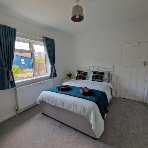 a bedroom with a bed with a blue blanket at Stylish bungalow with complimentary breakfast on the first morning in Lancing