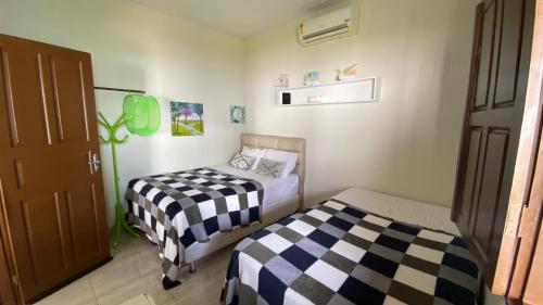 a bedroom with two beds and a door at Chácara Paraíso do Rio em Aracaju in Aracaju