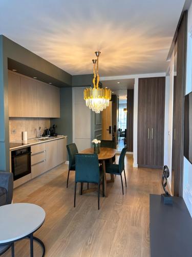 een keuken en eetkamer met een tafel en stoelen bij DOM Boutique Apartments - Verde in Belgrado