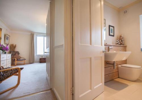 Baño blanco con lavabo y aseo en Salty House Shaldon, en Shaldon