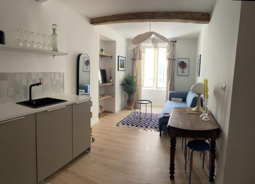 a kitchen with a table and a living room at Charmant appartement in Ajaccio