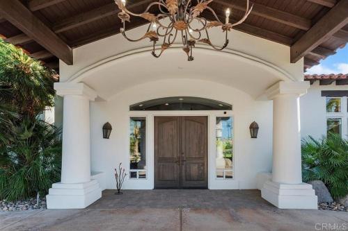 Über dem Eingang eines Hauses hängt ein Kronleuchter. in der Unterkunft Ultimate Luxury Retreat Over 1 4 Acres Pool Spa More in La Quinta