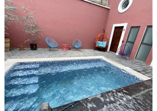 a swimming pool with two chairs and a house at Quinta La Perla in Guadalajara