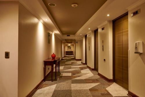 a hallway with a tile floor in a building at Plaza El Bosque Ebro in Santiago