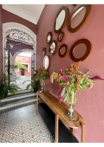 Habitación con mesa y espejos en la pared. en Quinta La Perla en Guadalajara