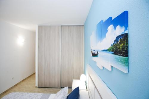カンブリルスにあるMAEVA HomeStay by Turismarの壁にボートの写真が描かれたベッドルーム