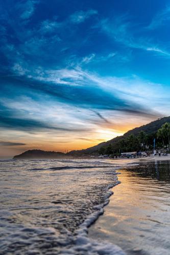 a view of a beach at sunset with the ocean at Pousada Irashai in Juquei