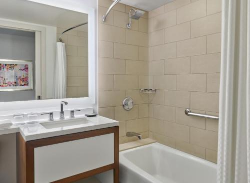 a bathroom with a white tub and a sink and a bath tubermott at The Westin Pasadena in Pasadena