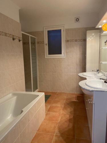 La salle de bains est pourvue d'une baignoire, de 2 lavabos et d'une baignoire. dans l'établissement Casa Orsini, à Nessa