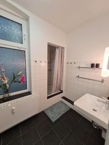 La salle de bains blanche est pourvue d'un lavabo et d'une fenêtre. dans l'établissement Ferienwohnung Ida an der Flensburger Förde, à Flensbourg